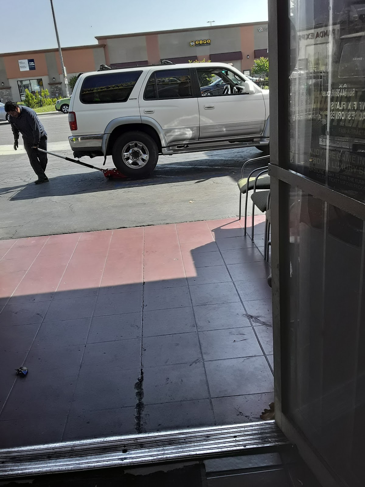 A Rivas technician jacking up a customer's truck at the curb
